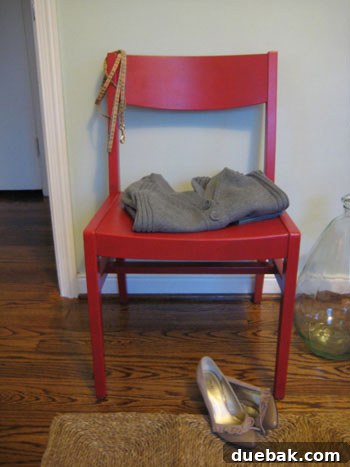 The fully transformed vintage wooden accent chair, now vibrant in semi-gloss red paint, placed in a modern setting.