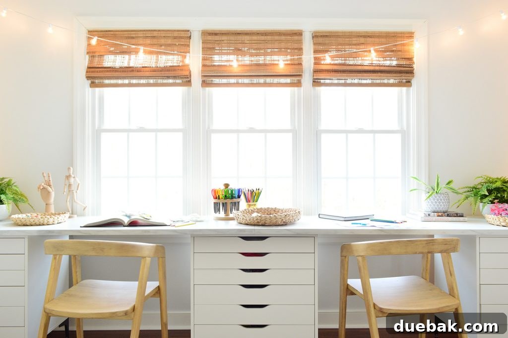 Straight View Of Kids Oversized Art Desk With Faux Marble Desktop In Front Of Window With String Lights