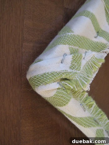 Detailed shot of an upholstered bench corner, showing precise fabric folding and stapling technique.
