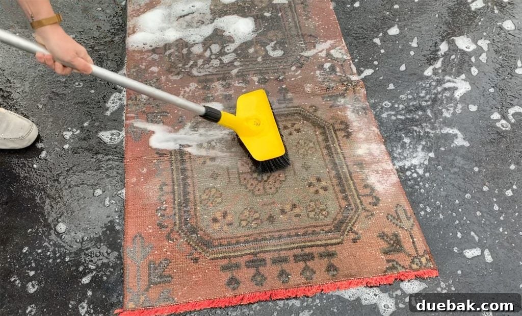 Revitalize Your Rug with a Pressure Washer 6 Scrubbing a vintage rug with a stiff brush and soapy water