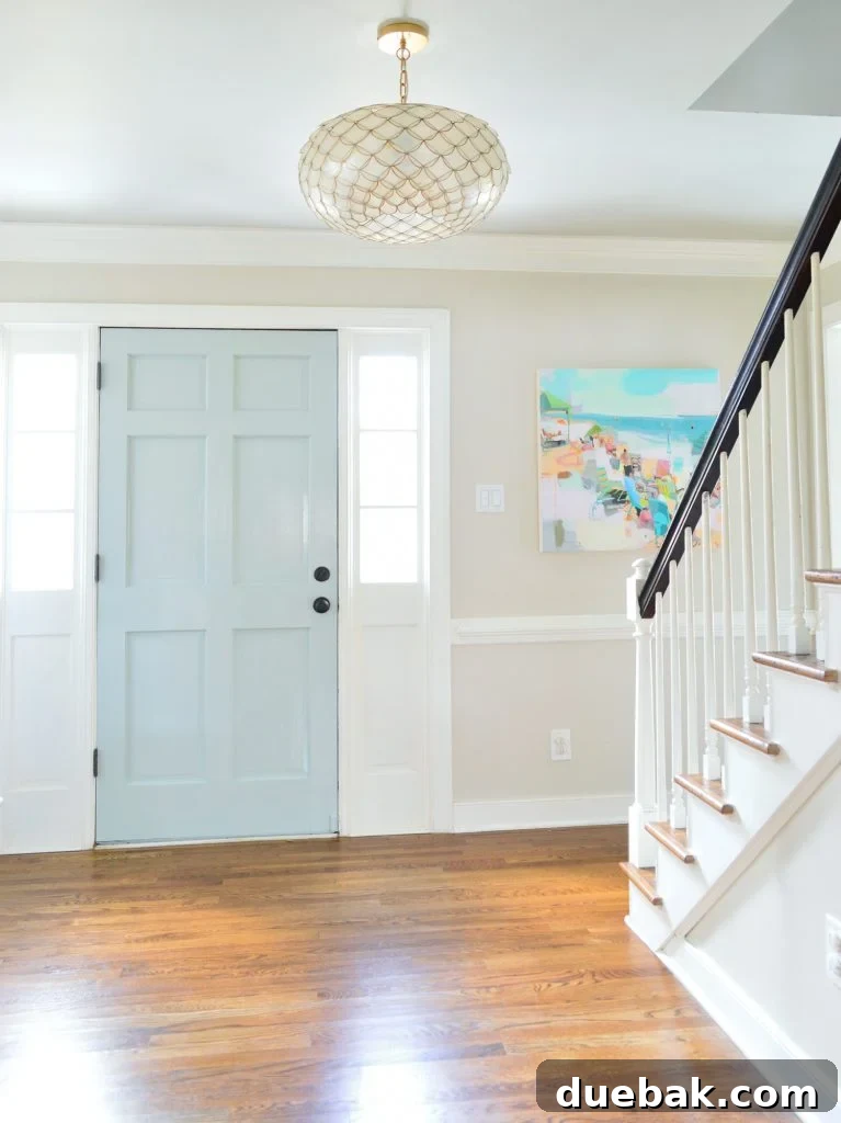 Our Petite Beach House: Maximizing Coastal Charm 2 A coastal-inspired living room with light blue walls, a woven rug, and bamboo blinds, hinting at a long-standing love for beach aesthetics.
