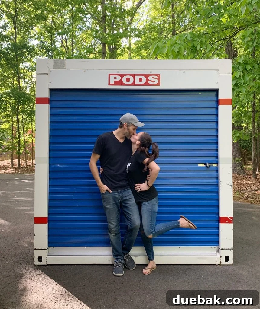Homeowners smiling next to a packed moving pod.
