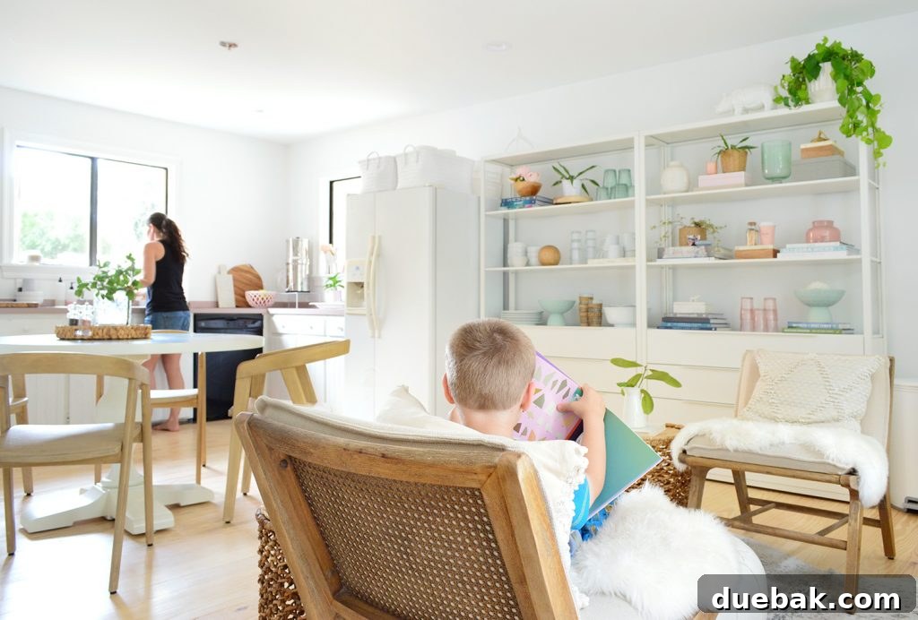 Compact Kitchen Living: Three Weeks In 16 A well-used sitting area with two chairs, a small table, and a vibrant rug, demonstrating its functionality and integration into the larger living space. The lighting is soft and inviting.