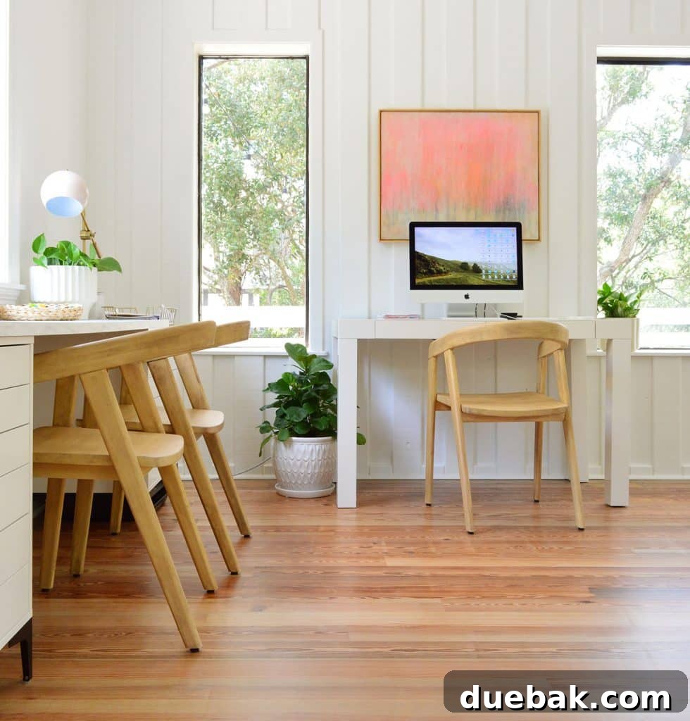 Life in Our Upstairs Family Room Four Weeks In 16 View of the shared family living room and office space, featuring two distinct desk areas with IKEA storage and a parsons desk, all against bright planked walls, promoting collaborative work.