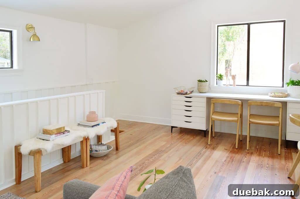 Life in Our Upstairs Family Room Four Weeks In 18 Upstairs landing area in the beachy living room showing empty floor space, with a kids' desk and two benches to the left, highlighting potential for future additions.