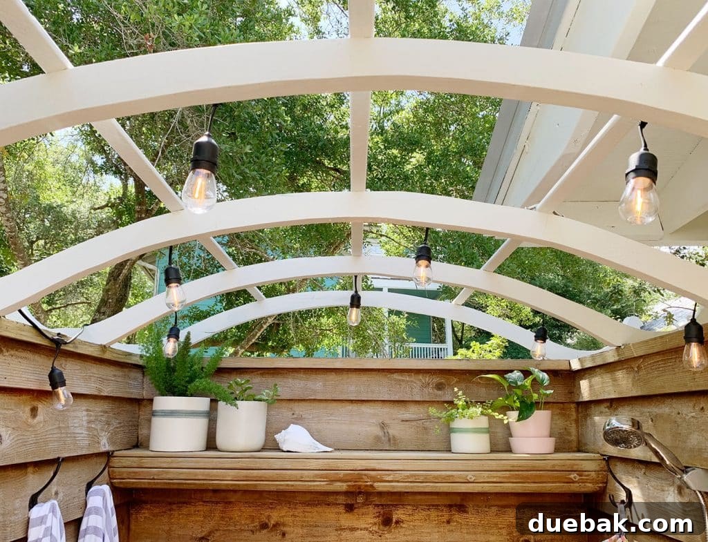 Close-up of the string lights installed along the wooden roof arches of the outdoor shower.