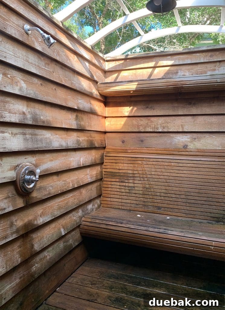 Before photo of the outdoor shower, showing dirty walls, floor, and old fixtures.