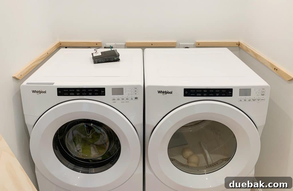 Wood laundry shelf supports added to walls besides washer and dryer