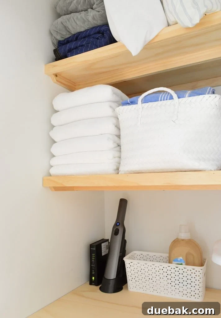 Towels and baskets stored on wood laundry shelves with support braces underneath