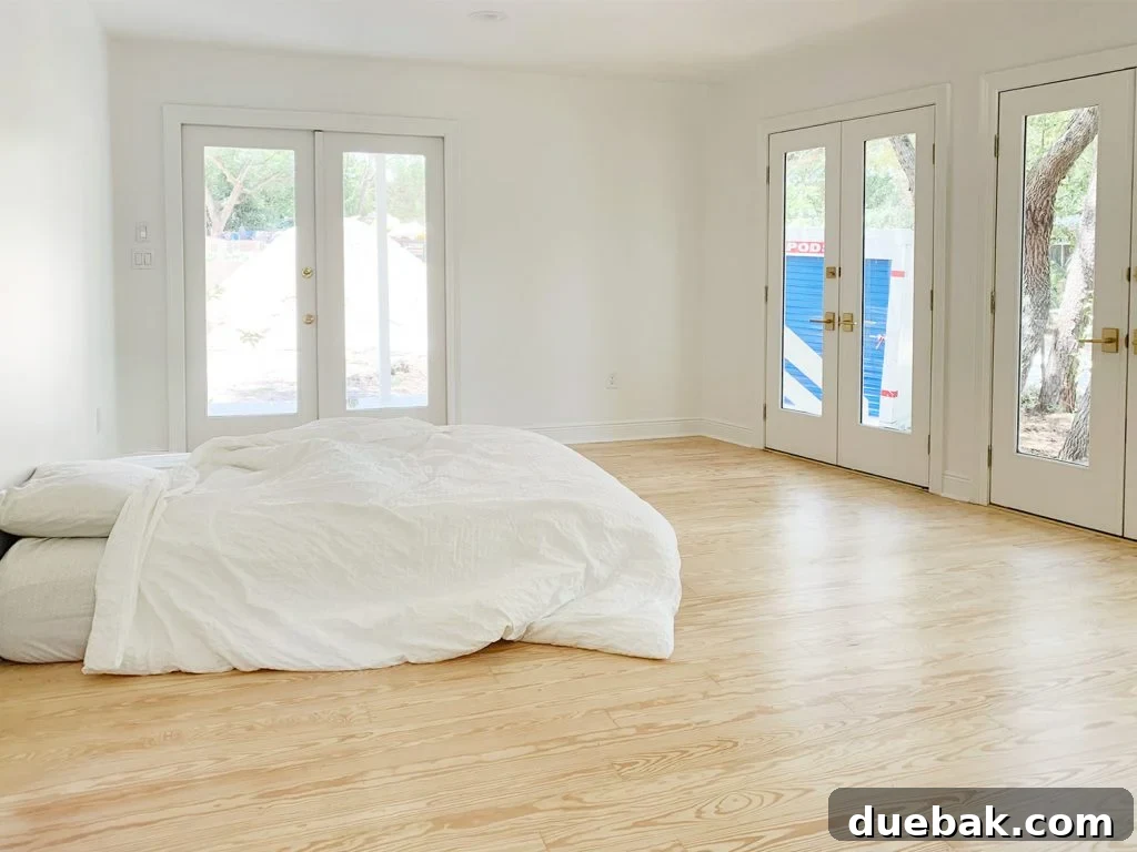 Bedroom Refresh: What's New and What's Next 7 Bedroom with large glass doors and a blue moving pod outside, before curtains were installed