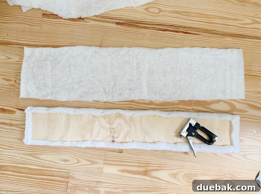 Craft Your Own Channel Tufted Headboard 12 A plywood panel wrapped in batting, ready for fabric upholstery.