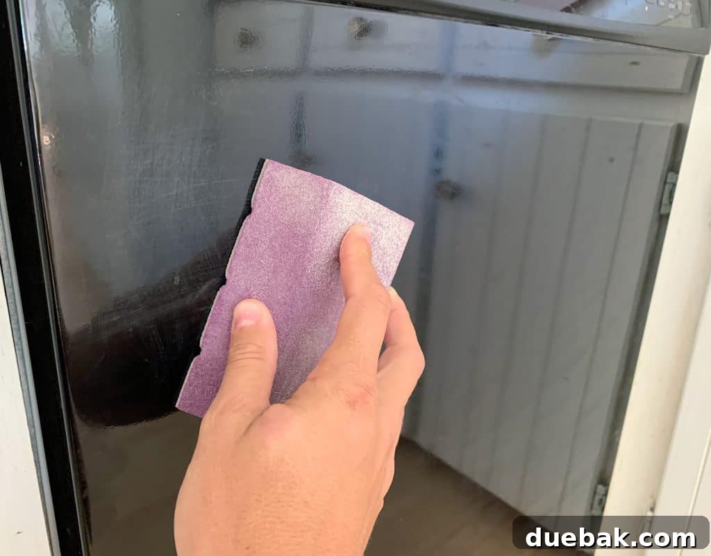 5 Speedy Kitchen Makeovers 12 Sanding Front Of Black Dishwasher To Prepare For Painting