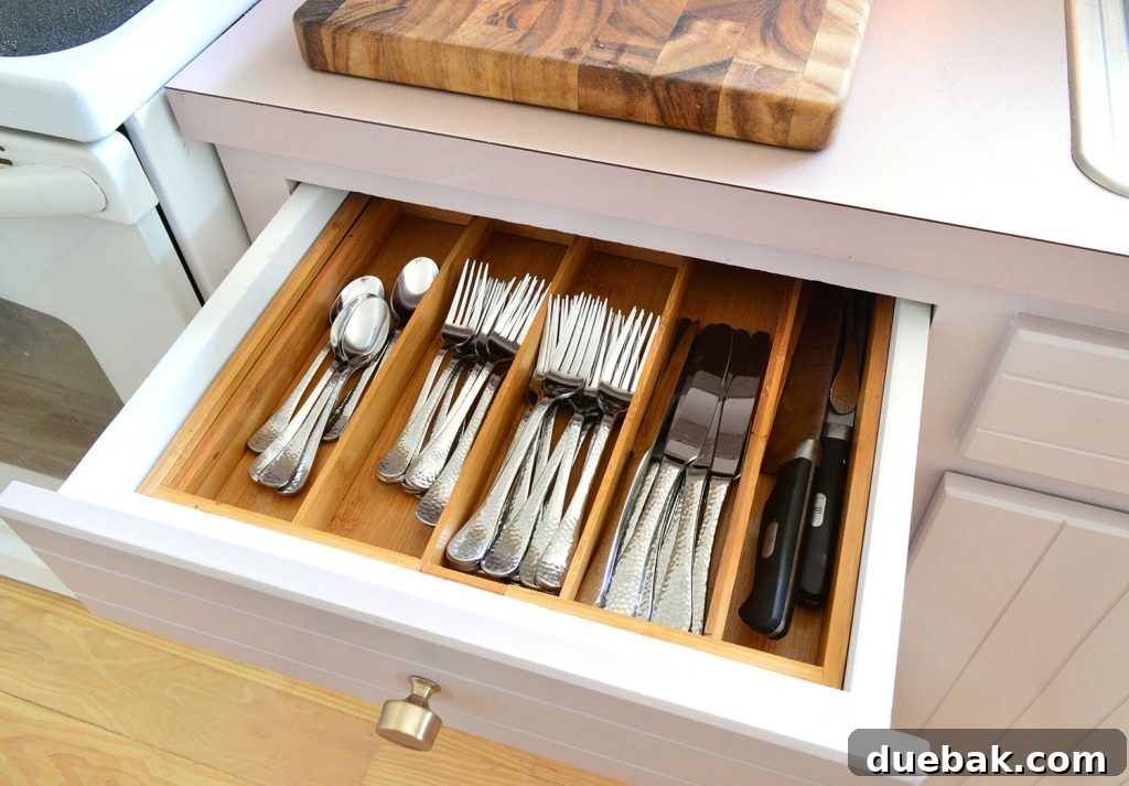 Kitchen drawer with organized flatware and knives using a bamboo organizer