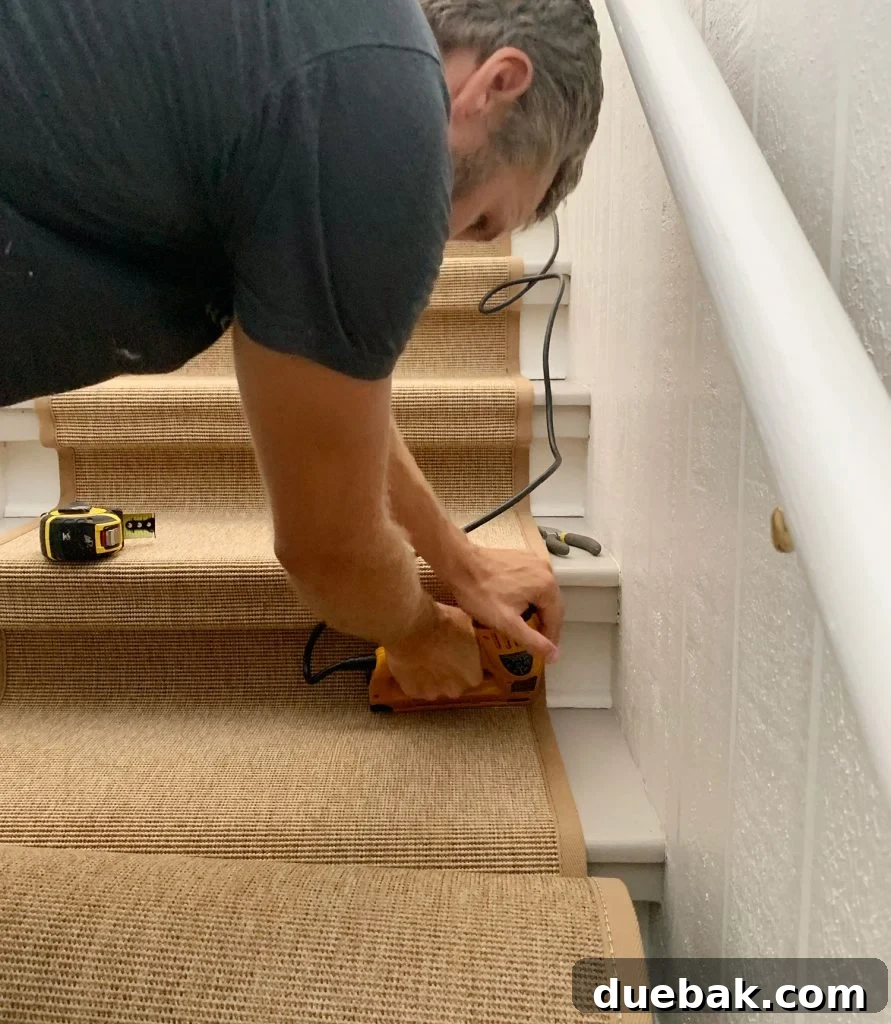 Step Up Your Style: Sisal Stair Runners 16 John Using Electric Staple Gun To Drive Staple Into Bottom Corner Of Stair To Secure Sisal Runner
