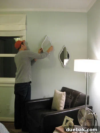 John diligently hanging elegant sconces on a bedroom wall
