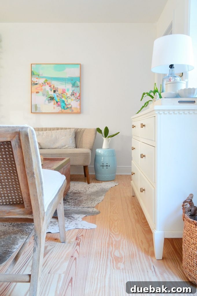 Functional entryway dropzone with a dresser between accent chairs in the sitting area
