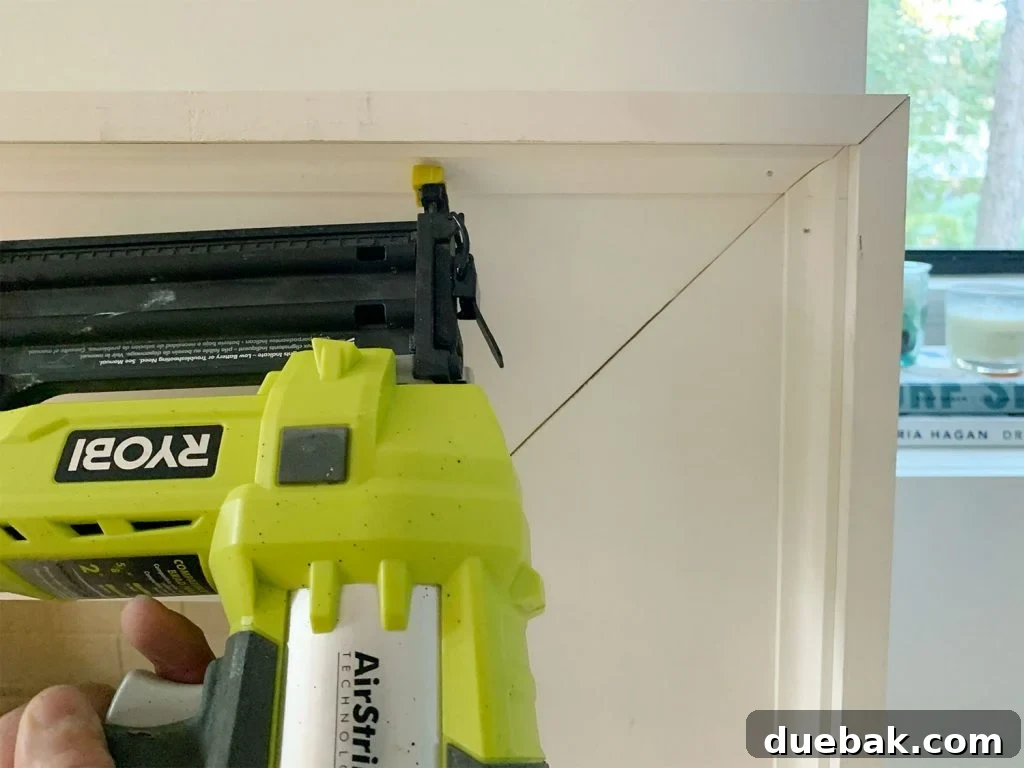 Nail Gun Securing Small Corner Trim Piece Along Inside Edge Of Mantel