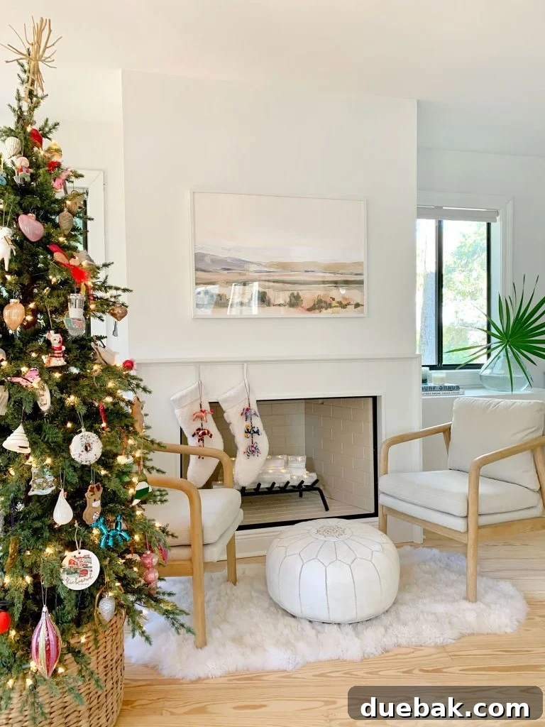 Christmas tree next to seating area in front of finished modern fireplace