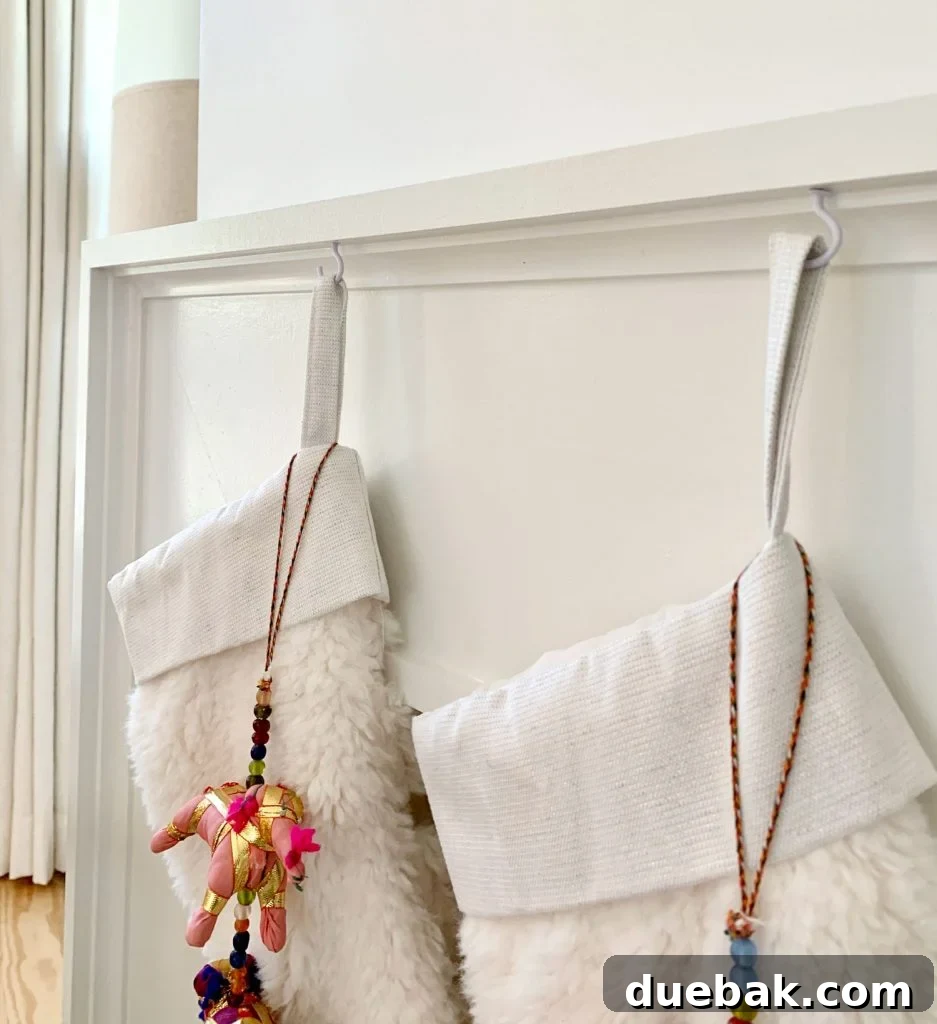 Close up detail of stockings hanging from mantel using small white cup hooks