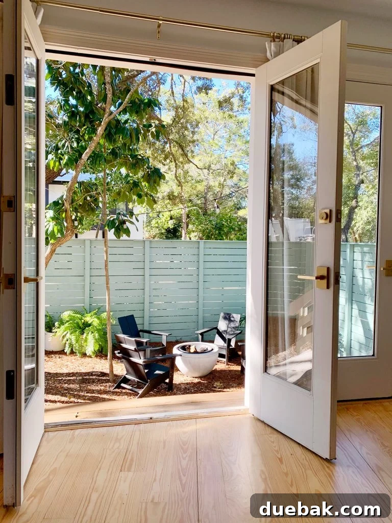 View of fire pit area through open french doors in bedroom