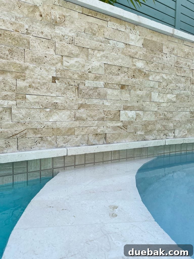 Detail photo of accent wall stacked natural stone tile and neutral waterline tile, showcasing cohesive design.
