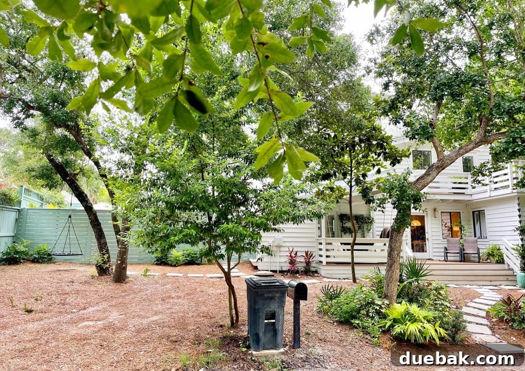 After photo of house from street with green fence in the background, illustrating the full transformation.