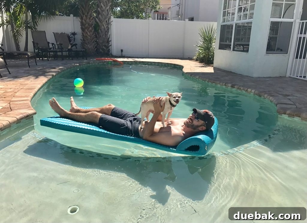 Burger making smiley face while on John's stomach in pool float