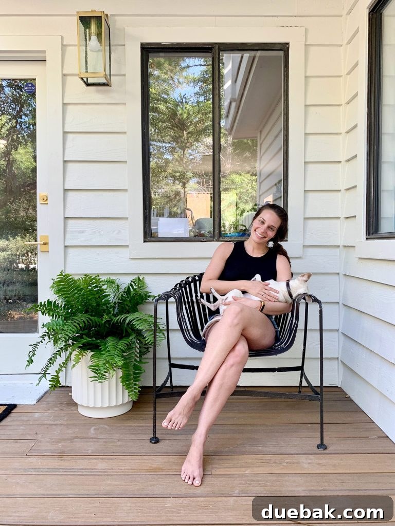 Sherry holding Burger on front porch chair