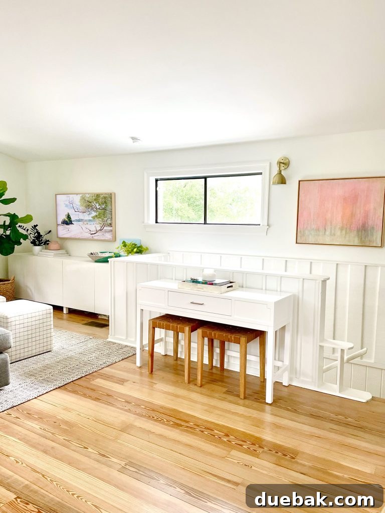 Console Table By Stairs In Upstairs Modern Family Room With White Paneled Wainscoting