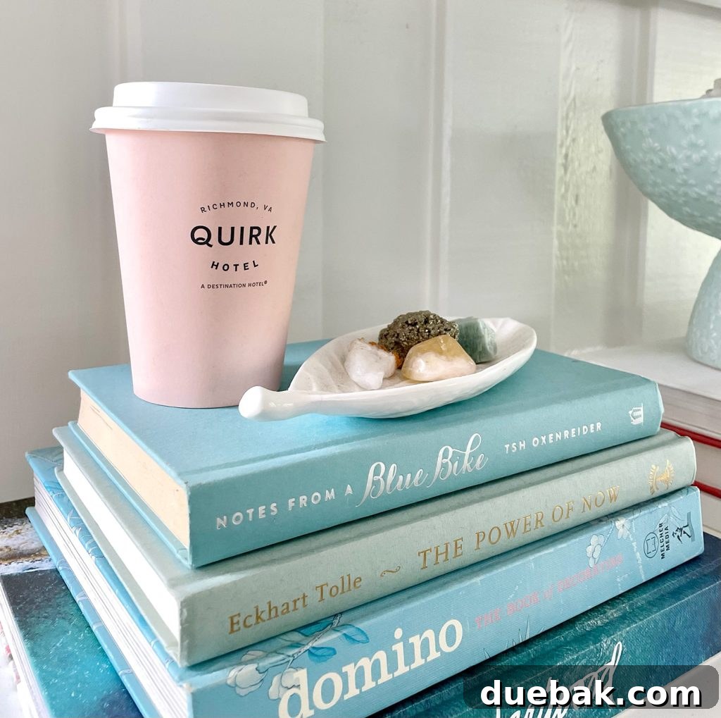Close Up Of Stack of Blue Books With Pink Quirk Hotel Coffee Cup