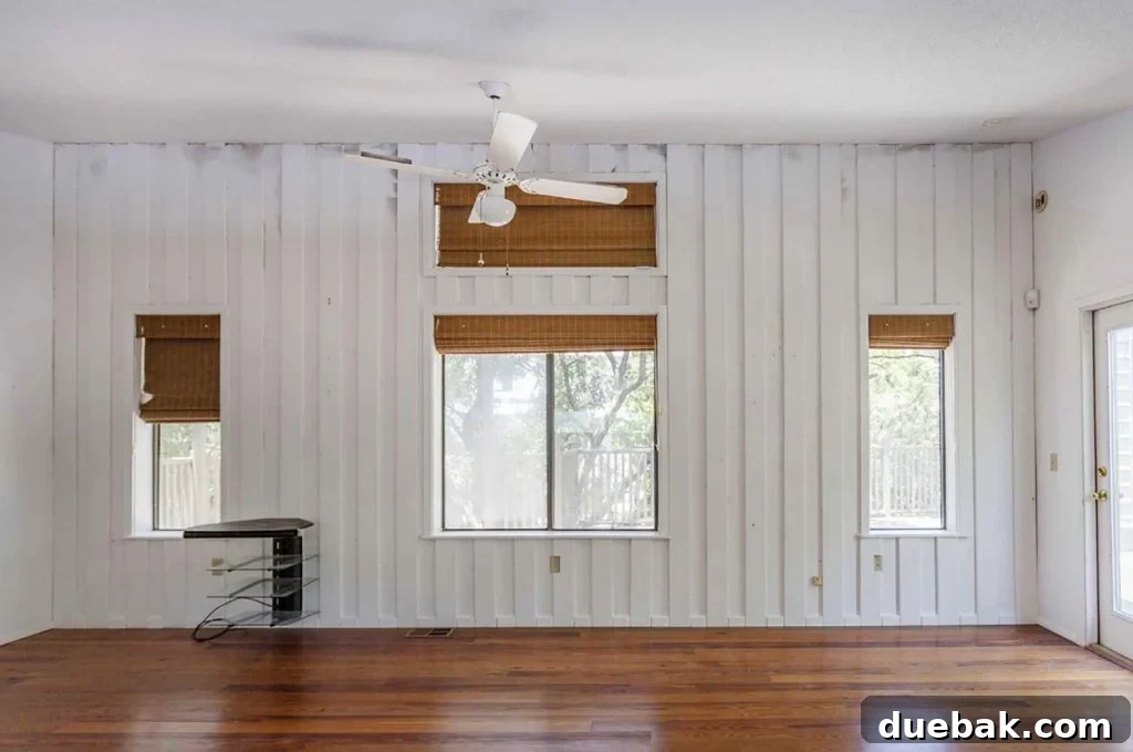 Before Photo of Upstairs Family Room With Moldy Walls And White Panelings