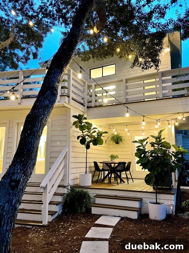 Night photo of the porch area, beautifully lit with string lights and warm glowing lights emanating from inside the house, creating a cozy atmosphere