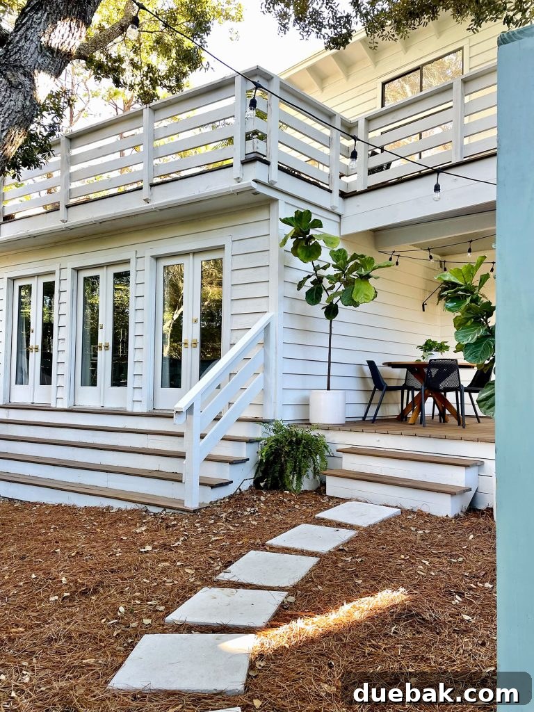Angled view through an open fence gate, revealing the inviting side porch yard area with visible doors leading to the bedroom