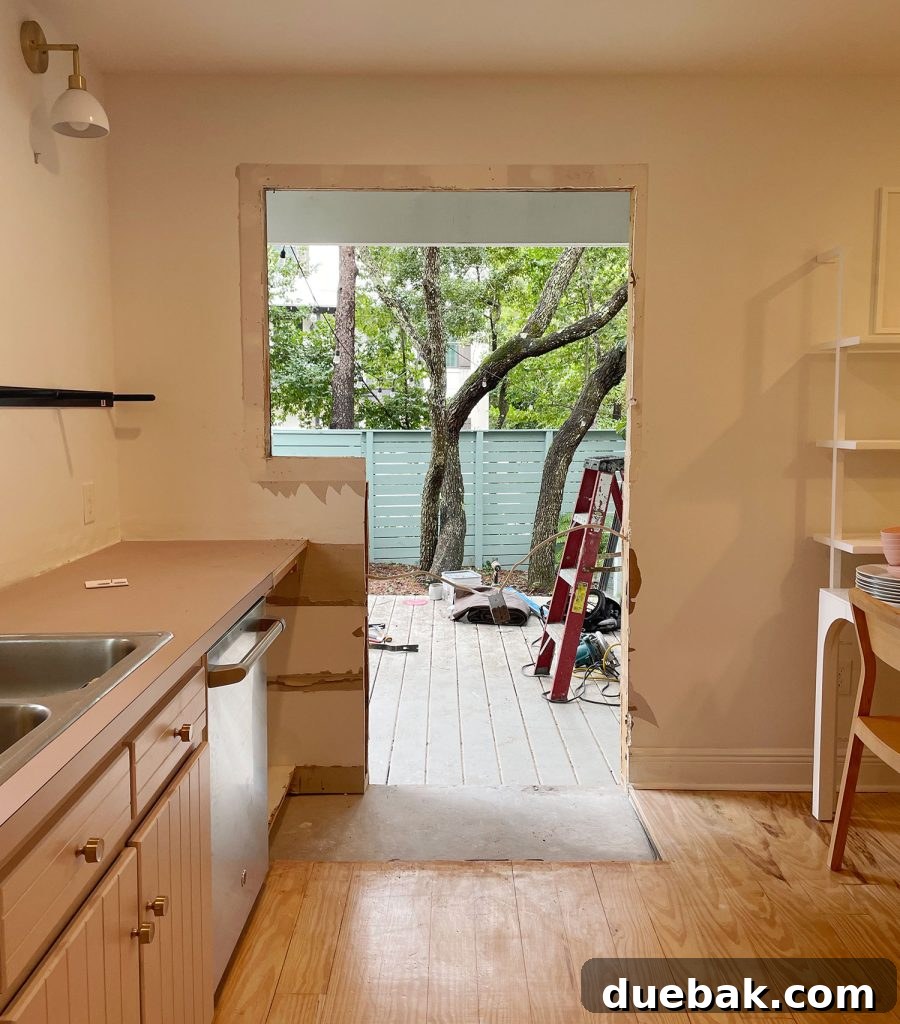 View from within the kitchen as the new doorway was being cut into the wall, revealing the initial glimpse of the outdoor space