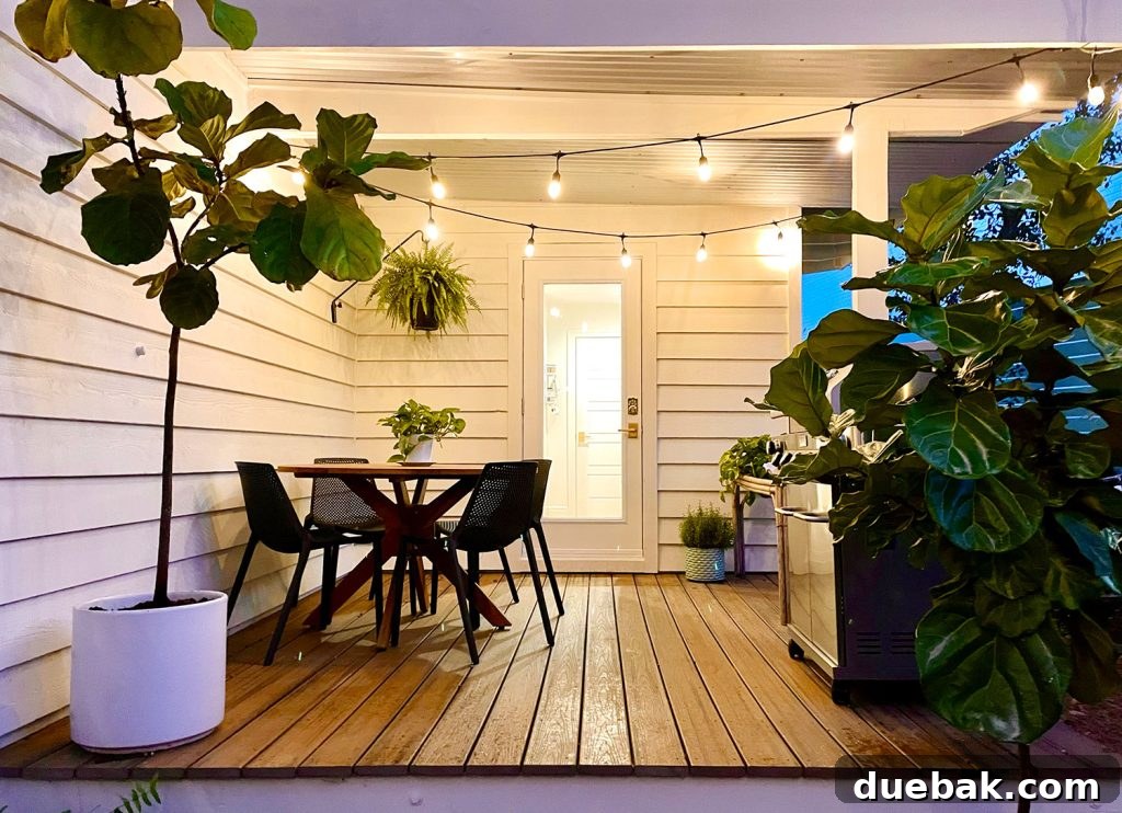 View of the outdoor dining table on the covered kitchen porch, bathed in the inviting glow of string lights