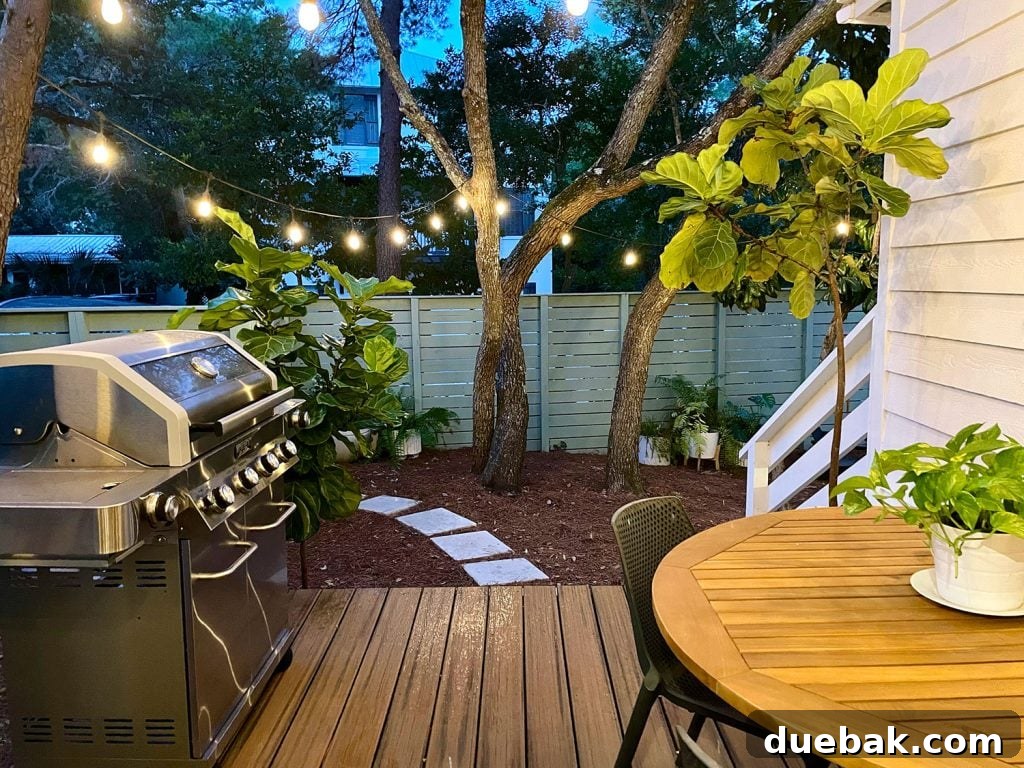 View looking out from the kitchen porch, with string lights glowing above the grill and dining table, creating an inviting atmosphere for eating