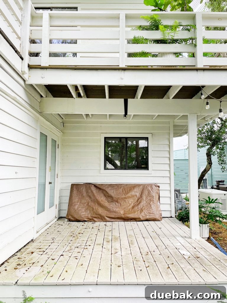 Midpoint photo of the covered porch with a freshly stained and painted floor, awaiting furniture and final touches, showcasing its temporary state