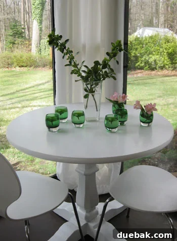 Close-up of small pink and green mums floating in clear glass votive candle holders, arranged as a minimalist and elegant floral display for home decor.