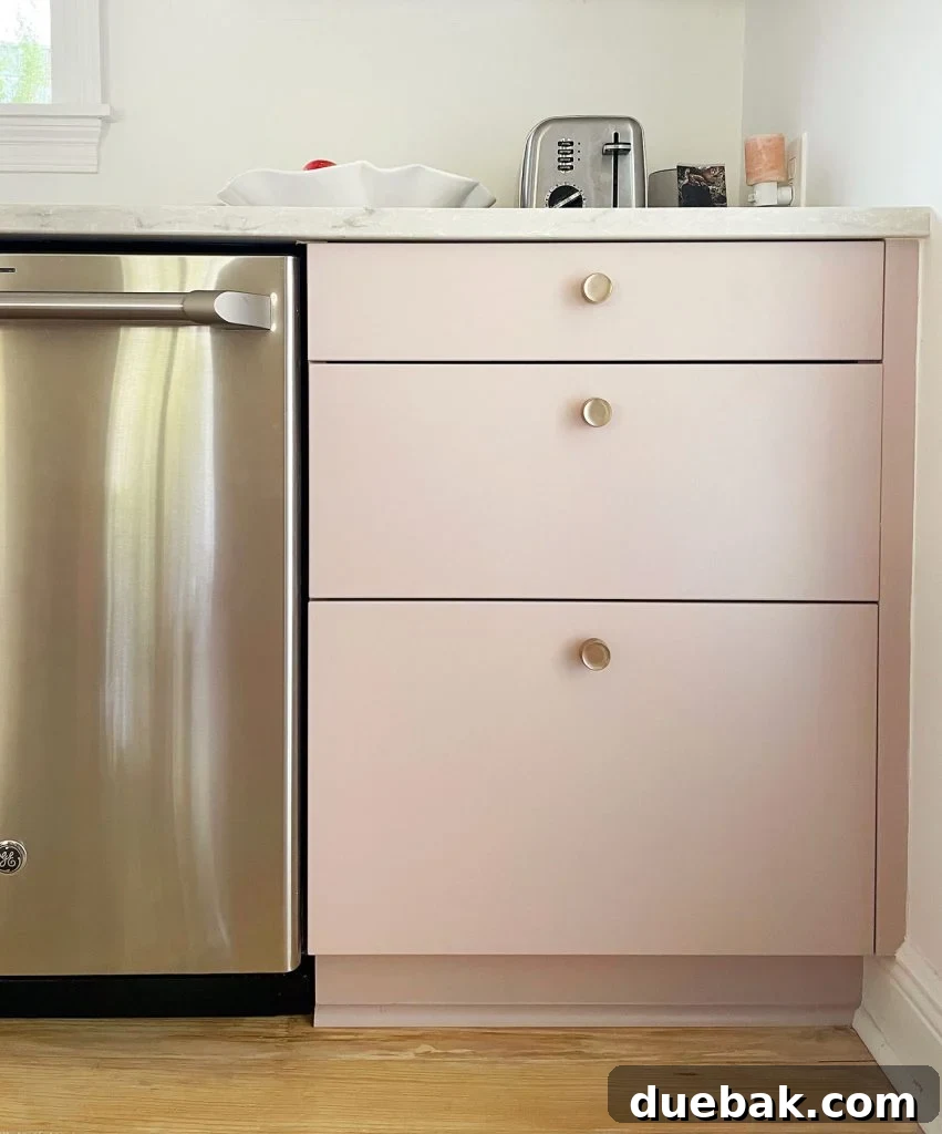 Completed Ikea kitchen with painted drawer fronts and brass knobs