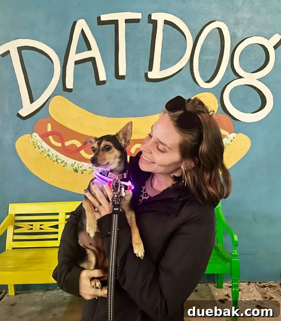 Sherry Holding Chihuahua In Front Of Dat Dog Mural New Orleans