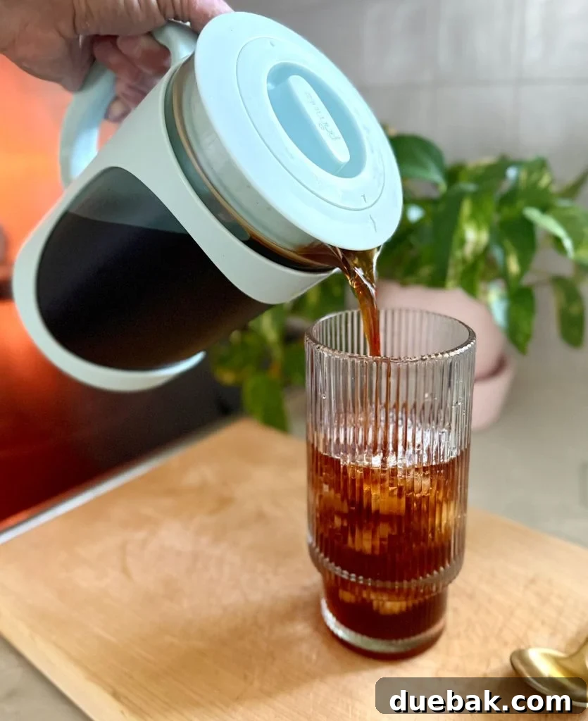 Pouring Homemade Cold Brew Into Glass With Ice