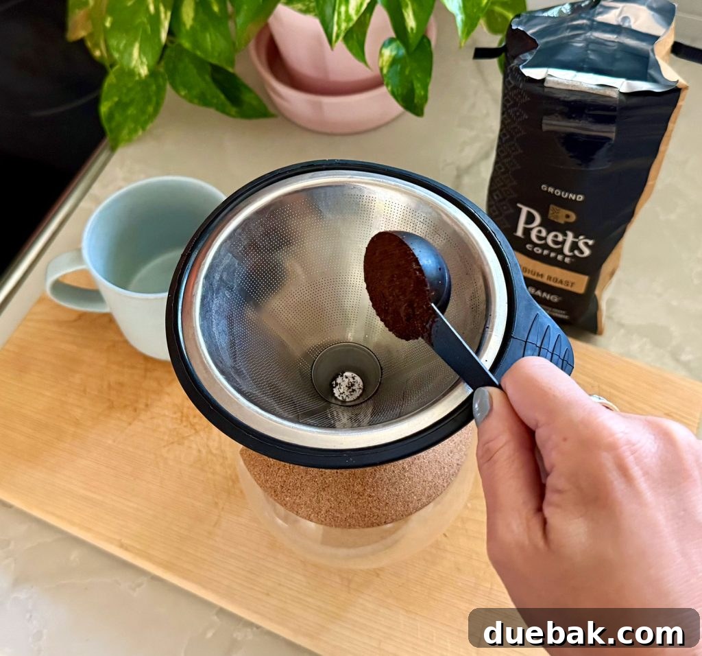Adding One Scoop of Ground Coffee Into Pour Over Coffee Maker