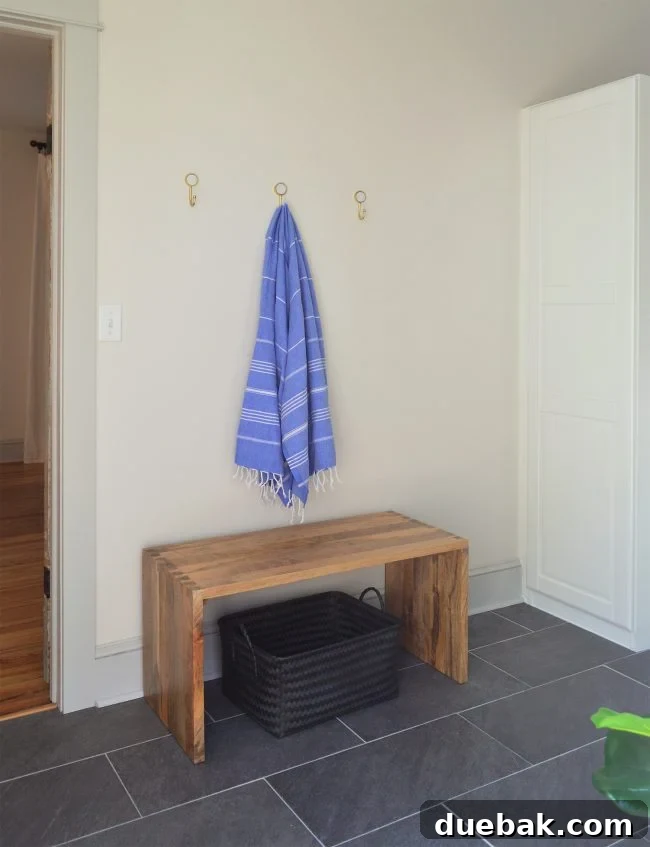 before photo with three gold hooks on wall in mudroom