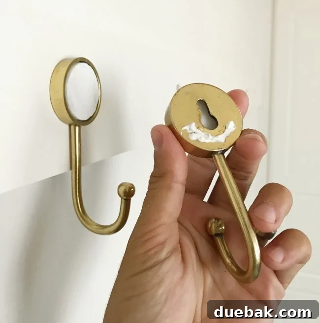 caulk on back of gold hook before being hung on wall