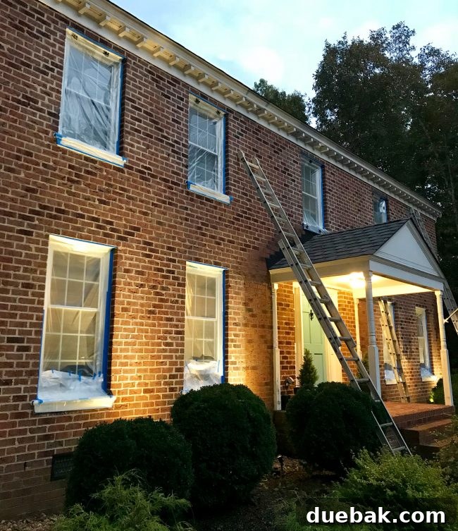 How We Transformed Our Brick House with White Paint 17 brick house prepped for painting with windows taped up