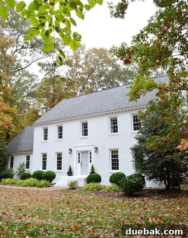 How We Transformed Our Brick House with White Paint 21 after photo of brick house painted moderne white with tranquility blue door