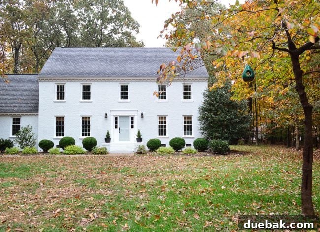 How We Transformed Our Brick House with White Paint 7 white painted brick house with fall leave and tranquility blue door