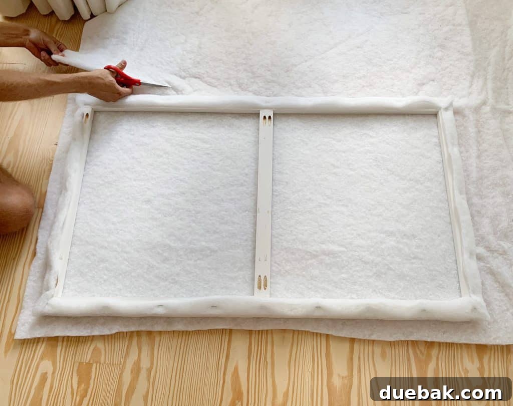 DIY Headboard Ideas: Simple Projects for a Stylish Bedroom 10 Cutting second layer of fabric batting for attaching to DIY upholstered headboard