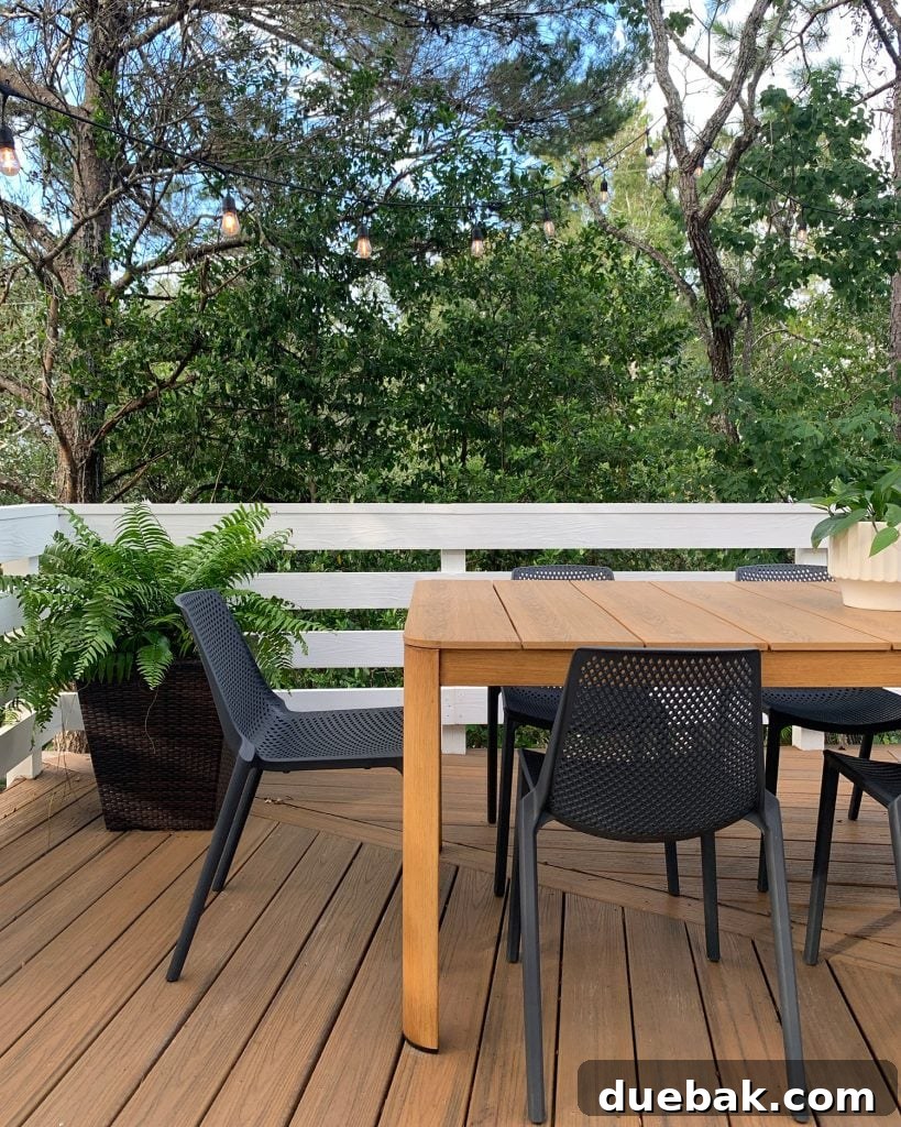 Close Up View Of Metal Faux Wood Table With Black Plastic Chairs