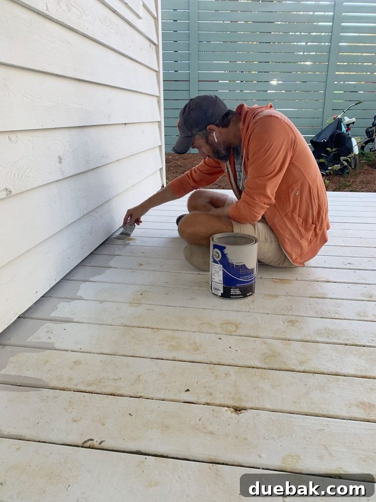 How to Paint a Porch Floor: Step-by-Step Guide for Lasting Results 5 John edging porch floor with gray floor paint on paintbrush